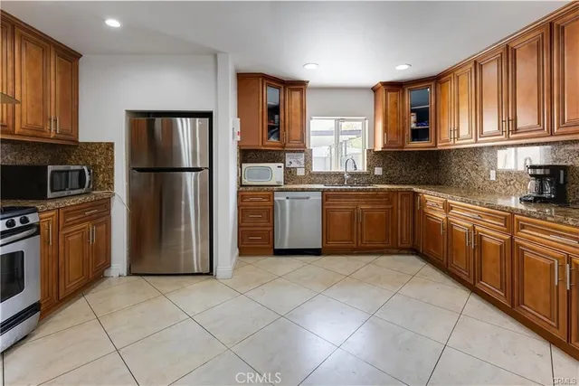 a kitchen with stainless steel appliances granite countertop a refrigerator sink and cabinets