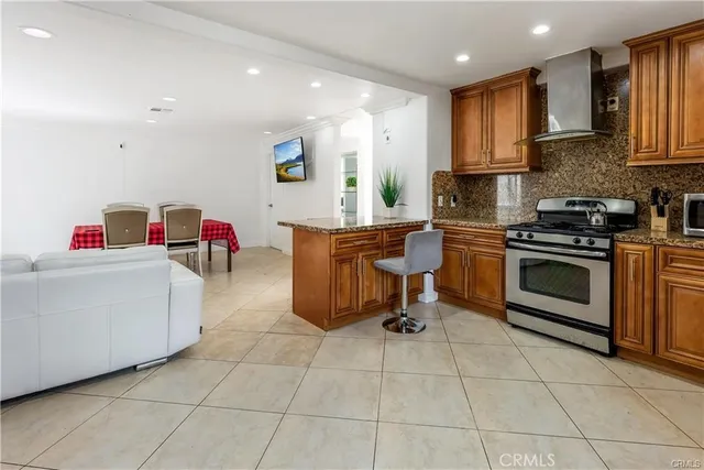 a kitchen with stainless steel appliances kitchen island granite countertop a sink and a stove