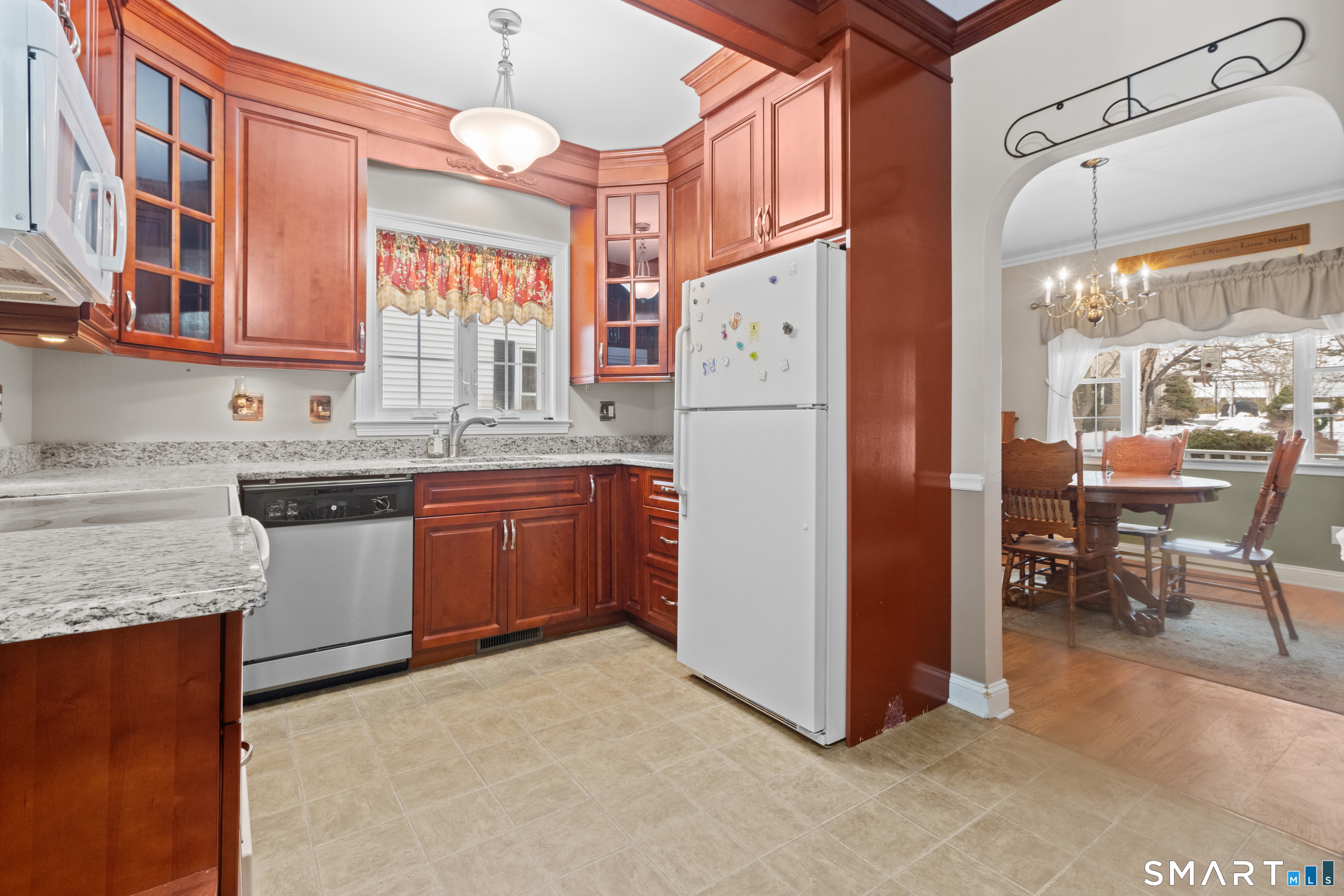 826 South Main Street Seymour, CT 06483 - Photo 6 of 27 a kitchen with a refrigerator a sink dishwasher a stove and a dining table with wooden cabinet