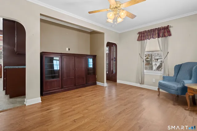 a view of an empty room with window and wooden floor