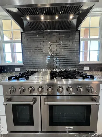 a stove top oven sitting inside of a kitchen
