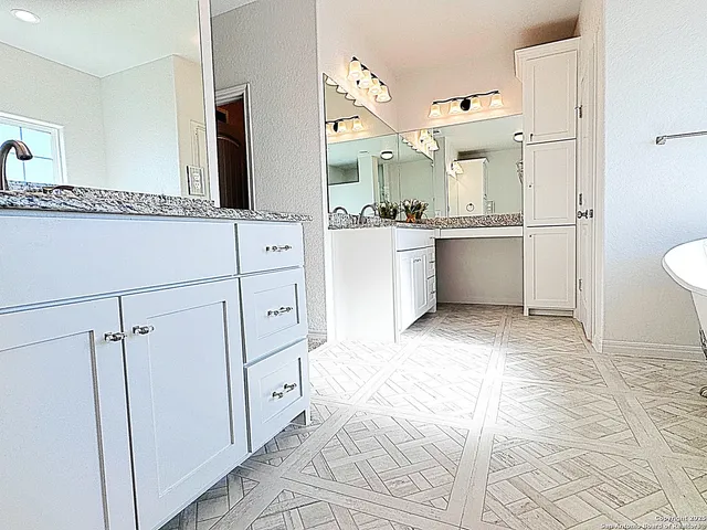 a large white bathroom with a granite countertop sink mirror and a bathtub
