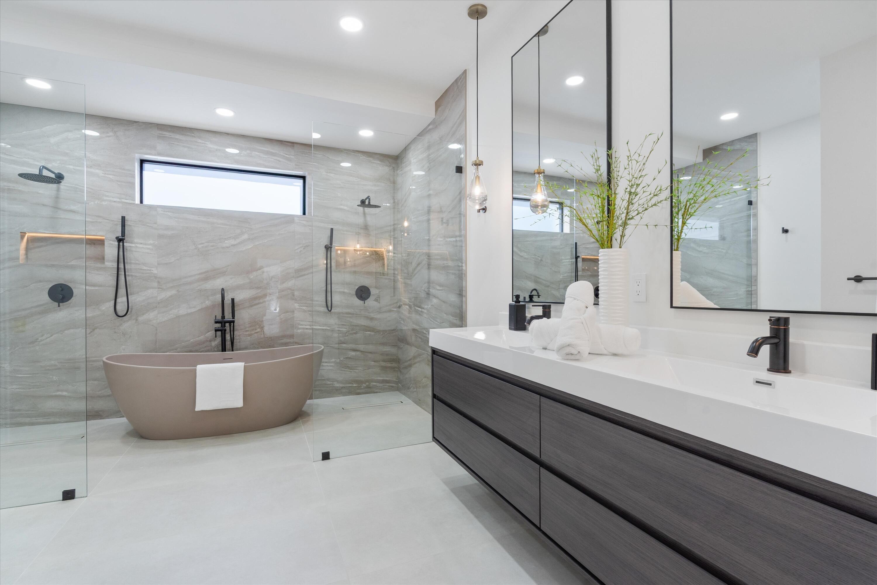 3721 Northeast 30th Avenue Lighthouse Point, FL 33064 - Photo 28 of 70 a bathroom with a double vanity sink a mirror and a bathtub