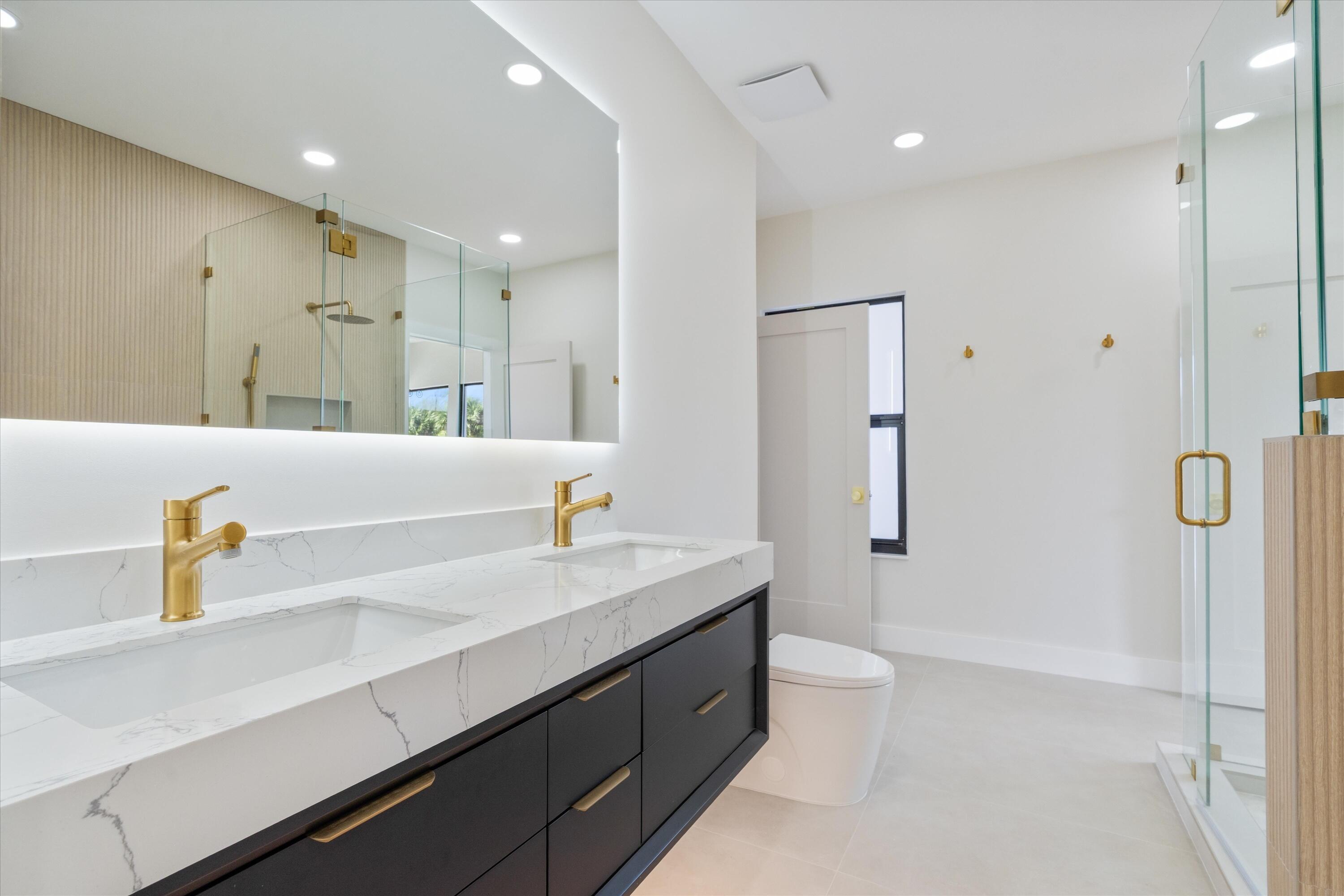 3721 Northeast 30th Avenue Lighthouse Point, FL 33064 - Photo 33 of 70 a bathroom with a sink a toilet and shower