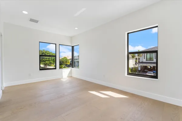 a front view of a building with glass windows and palm tree