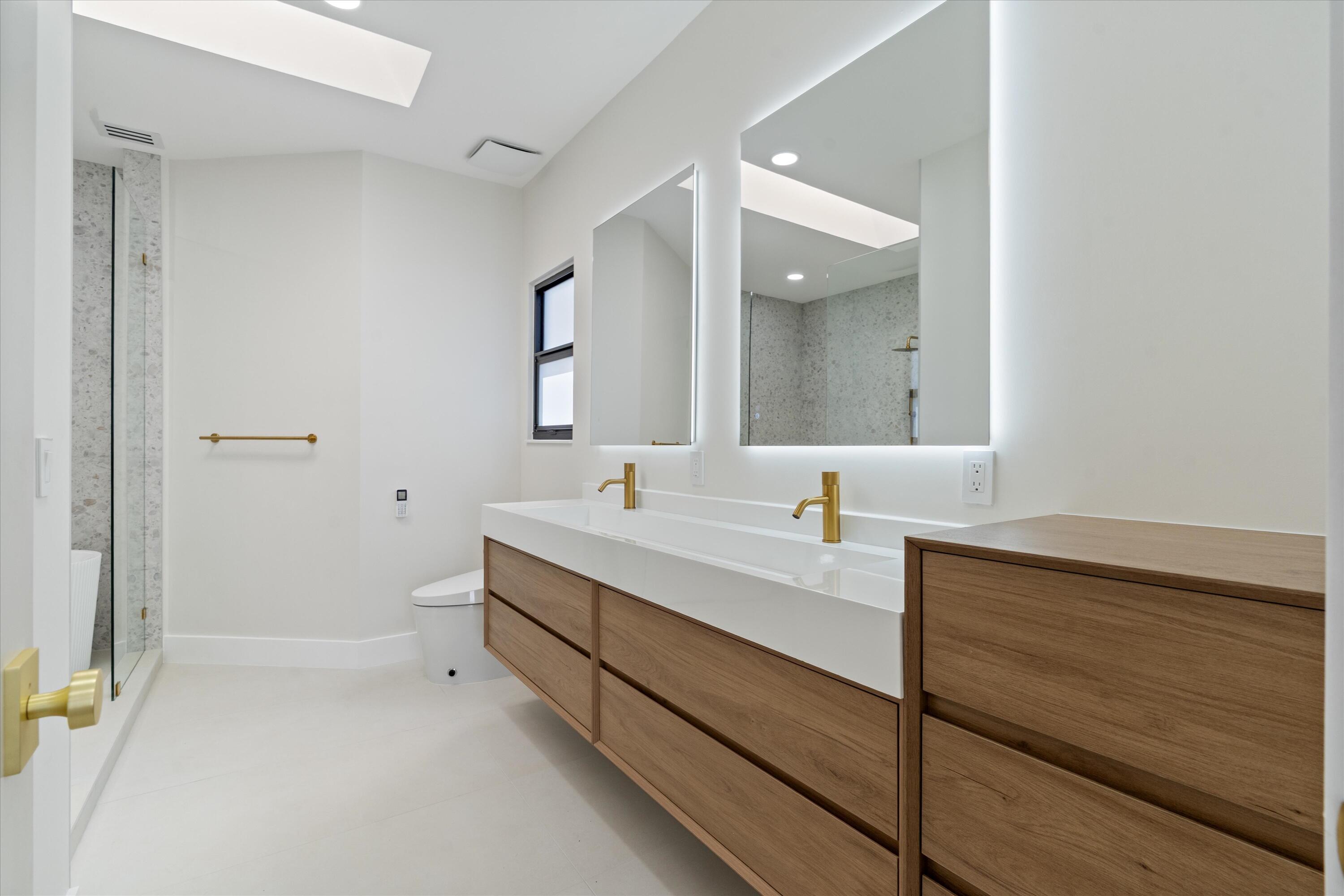 3721 Northeast 30th Avenue Lighthouse Point, FL 33064 - Photo 40 of 70 a bathroom with a double vanity sink and mirror with shower