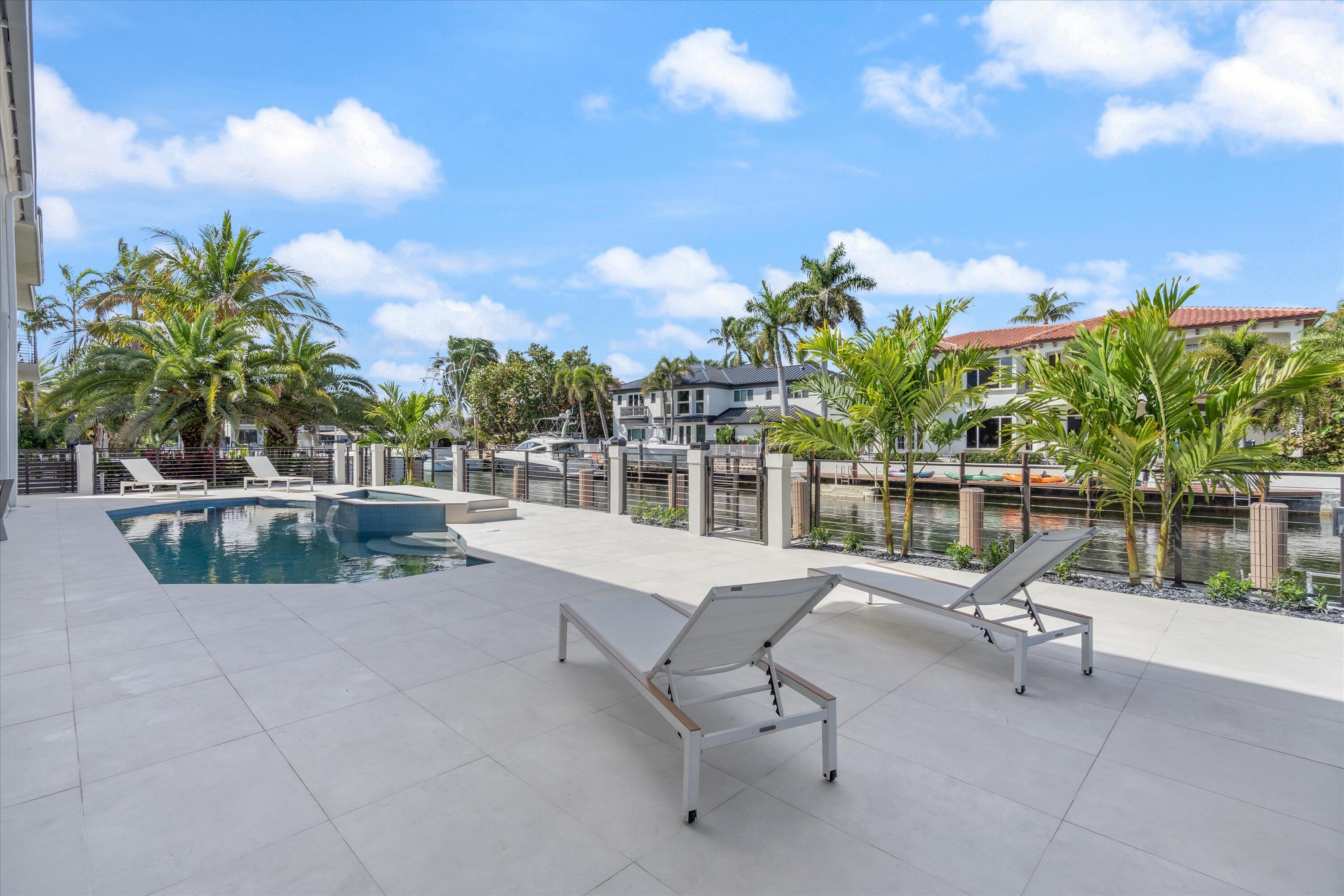 3721 Northeast 30th Avenue Lighthouse Point, FL 33064 - Photo 51 of 70 a view of a swimming pool with a patio and a garden
