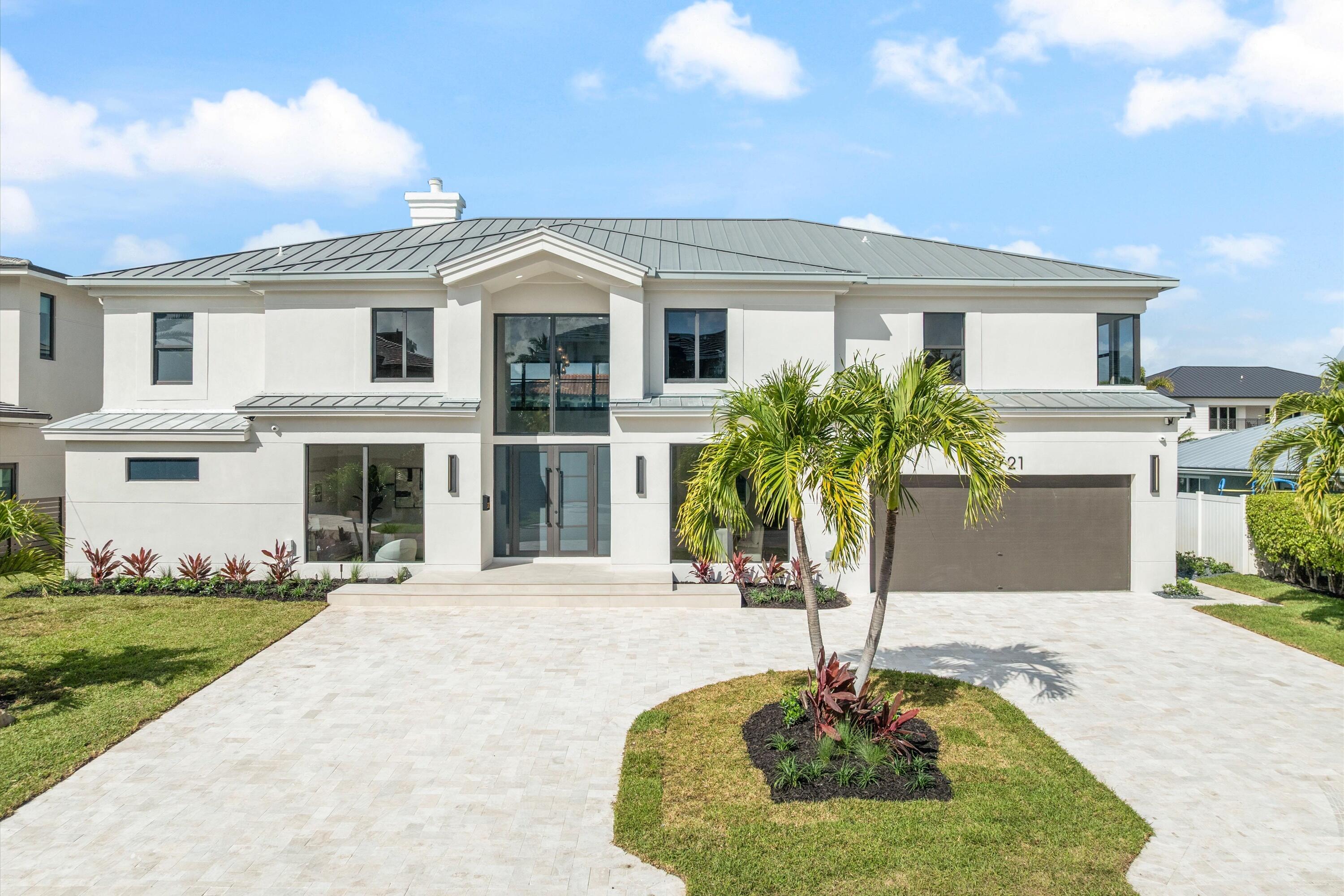 3721 Northeast 30th Avenue Lighthouse Point, FL 33064 - Photo 61 of 70 a front view of a house with yard and garage