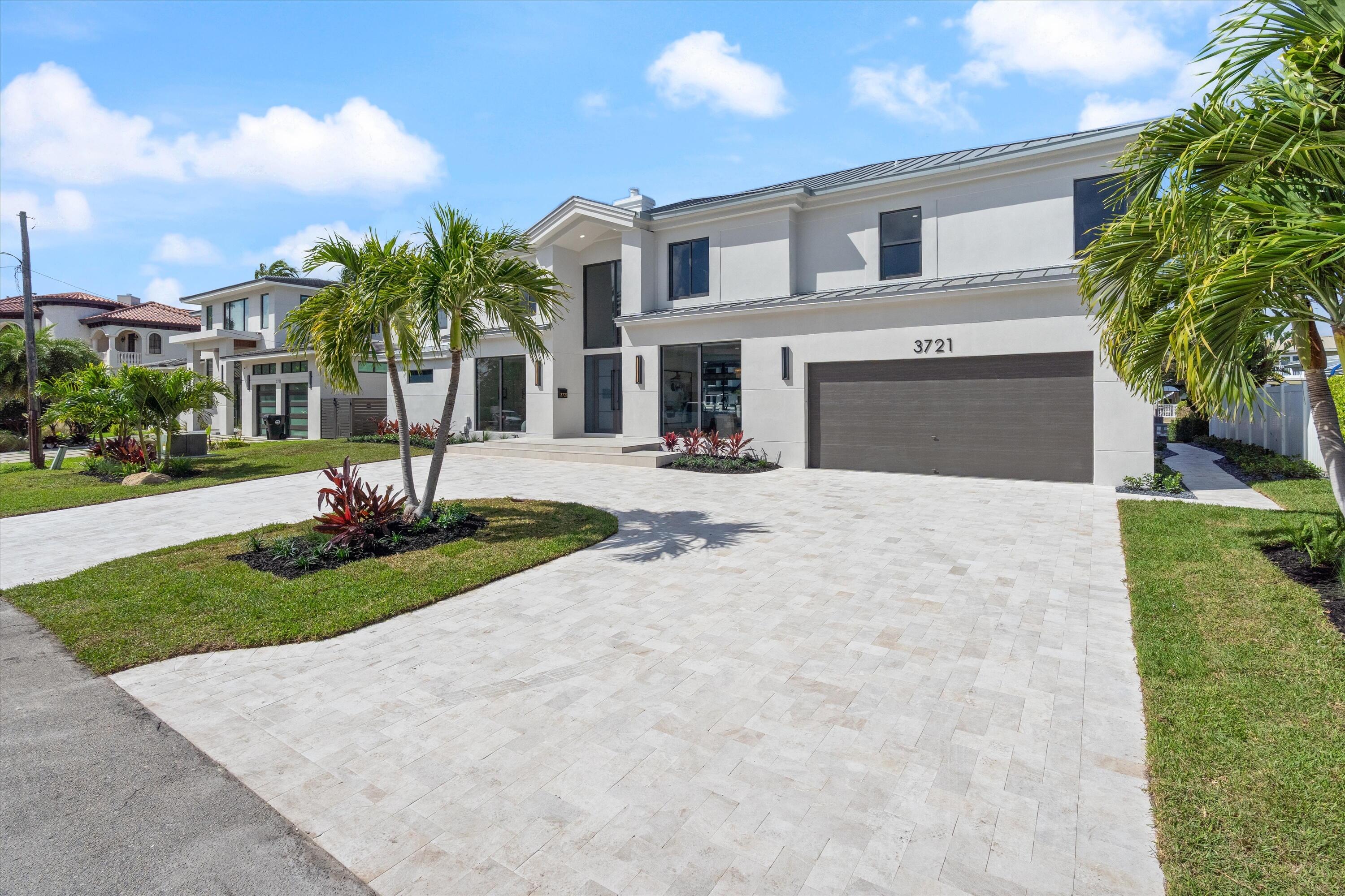 3721 Northeast 30th Avenue Lighthouse Point, FL 33064 - Photo 65 of 70 a front view of a house with a yard and garage