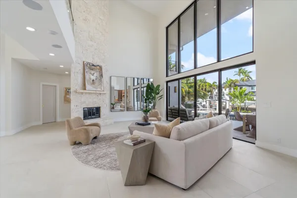 a kitchen with granite countertop a sink and white cabinets with a large window
