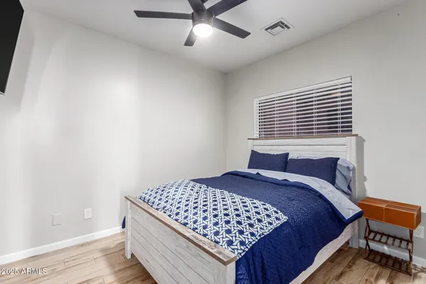 a bedroom with a bed and wooden floor