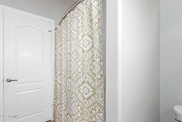 a bathroom with a shower curtain and a toilet