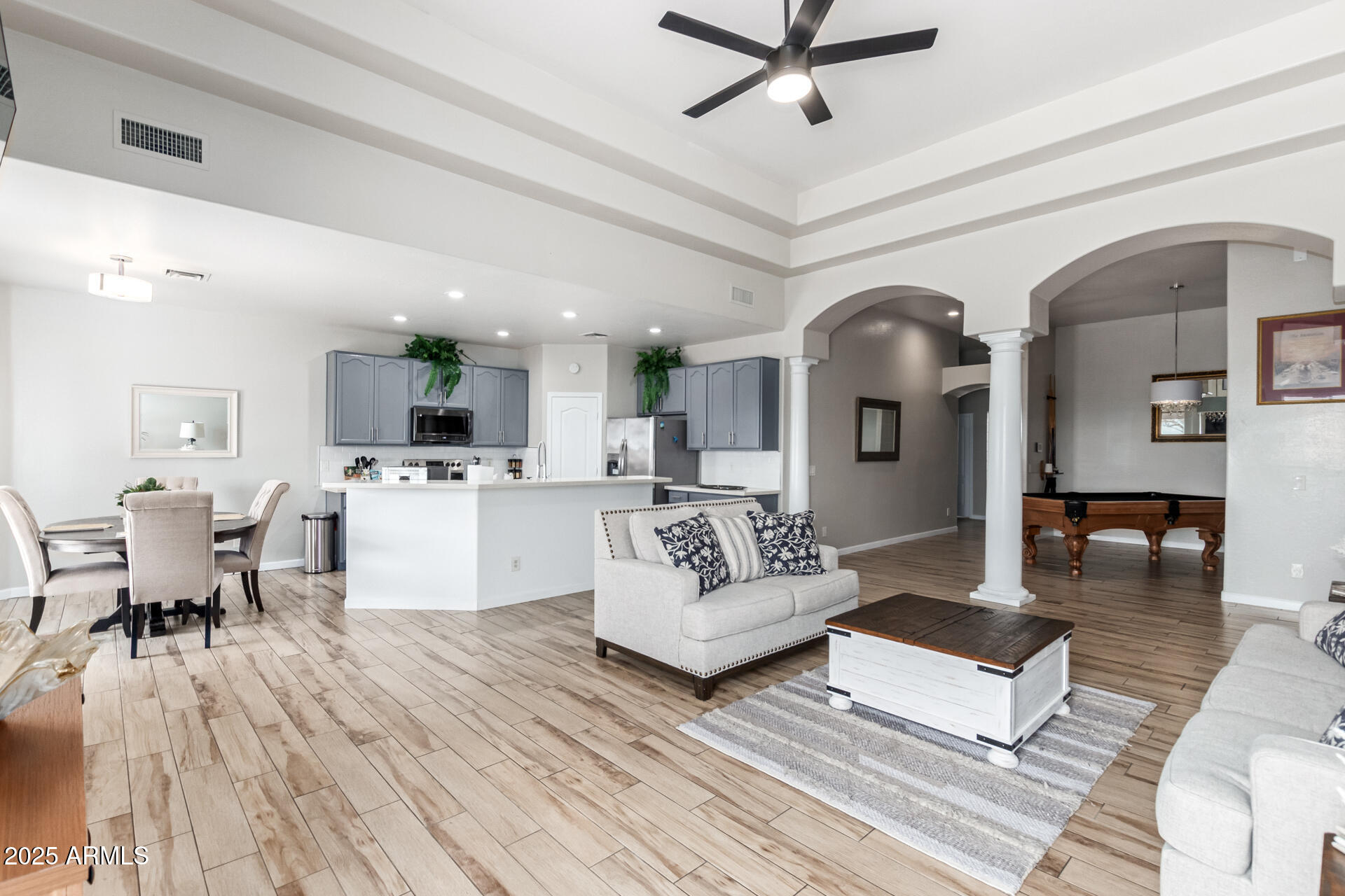8632 South 10th Lane Phoenix, AZ 85041 - Photo 2 of 31 a living room with couches and kitchen view with wooden floor