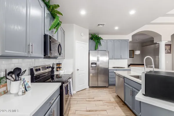 a kitchen with kitchen island granite countertop a sink stainless steel appliances and cabinets