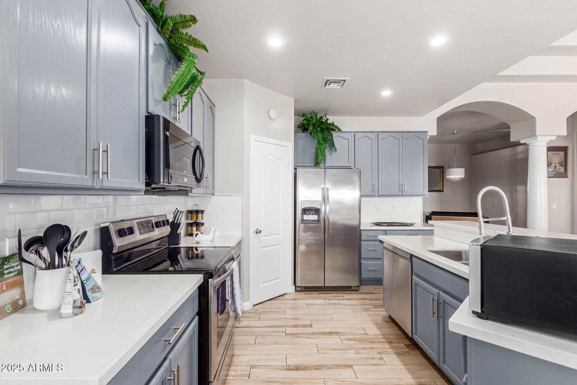 8632 South 10th Lane Phoenix, AZ 85041 - Photo 5 of 31 a kitchen with kitchen island granite countertop a sink stainless steel appliances and cabinets