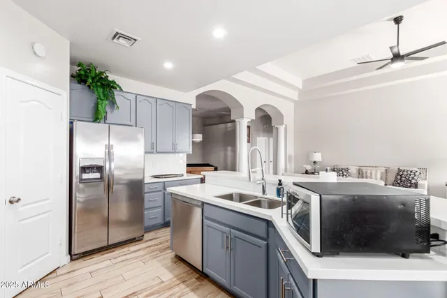 a kitchen with stainless steel appliances granite countertop a sink a stove a refrigerator and cabinets