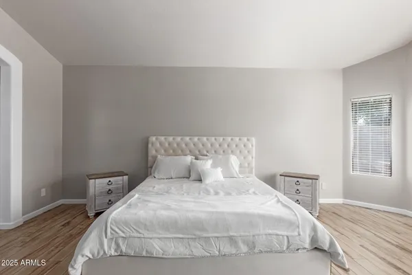 a bedroom with a bed and wooden floor