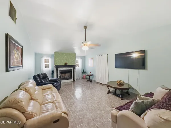 a living room with furniture a fireplace and a flat screen tv