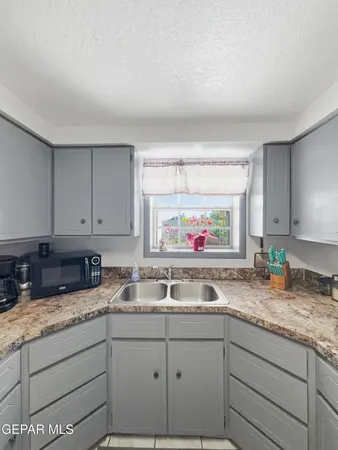 a kitchen with granite countertop a sink and a stove top oven