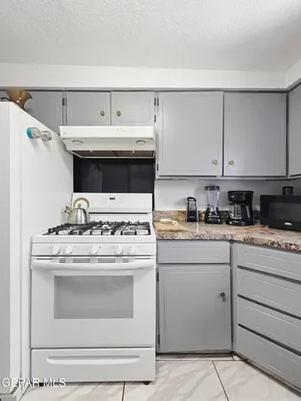 a kitchen with a stove and white cabinets