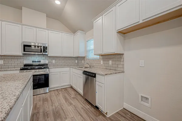 a kitchen with stainless steel appliances granite countertop a stove and a sink
