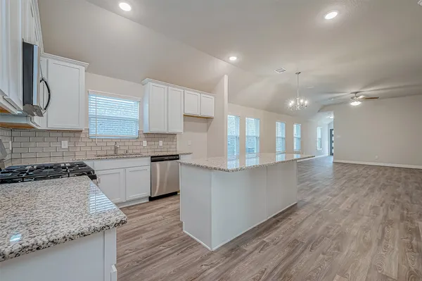 a kitchen with granite countertop white cabinets and white appliances