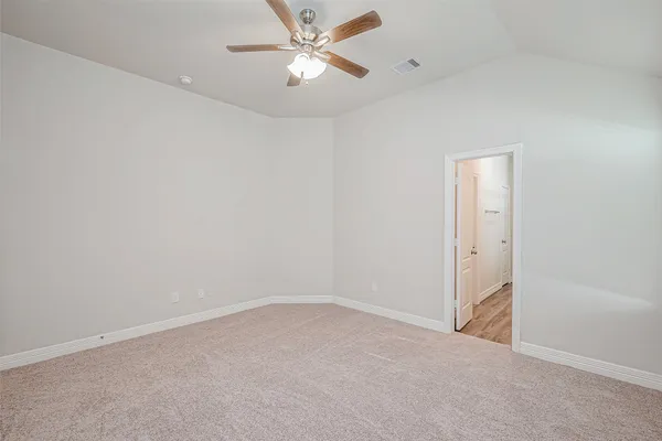 an empty room with a ceiling fan and a window