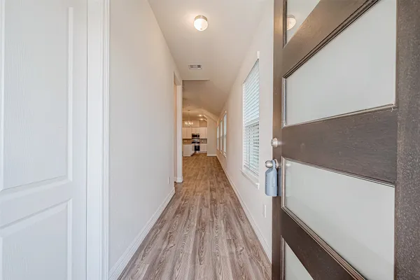 a view of a hallway with wooden floor and staircase