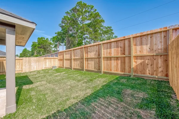 a view of a backyard with wooden fence
