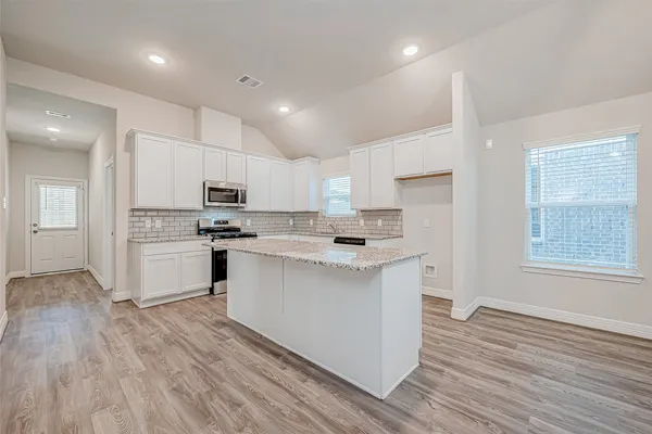 a kitchen with white cabinets and stainless steel appliances
