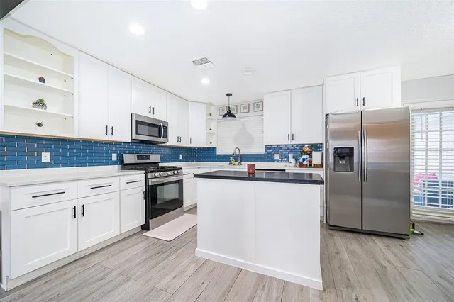 a kitchen with stainless steel appliances a refrigerator sink and microwave