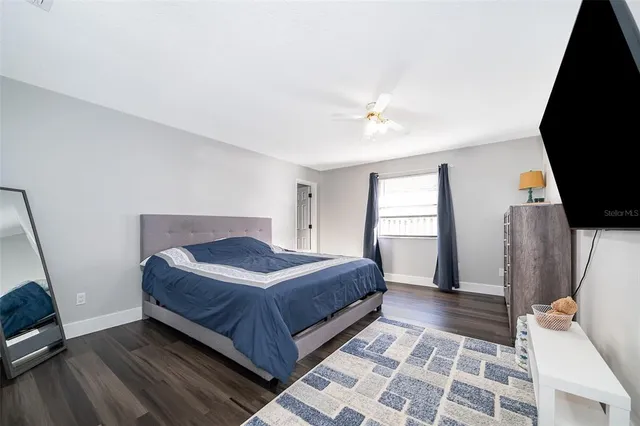 a bedroom with a bed and a flat tv screen on a dresser