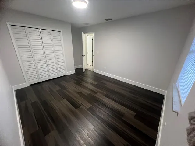 a view of empty room with wooden floor