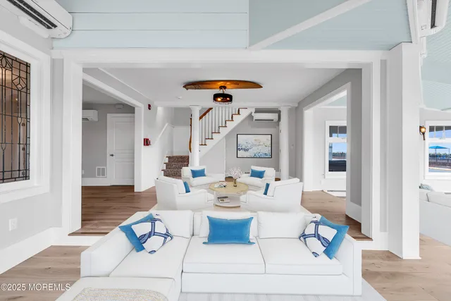 a view of an empty room with wooden floor and window