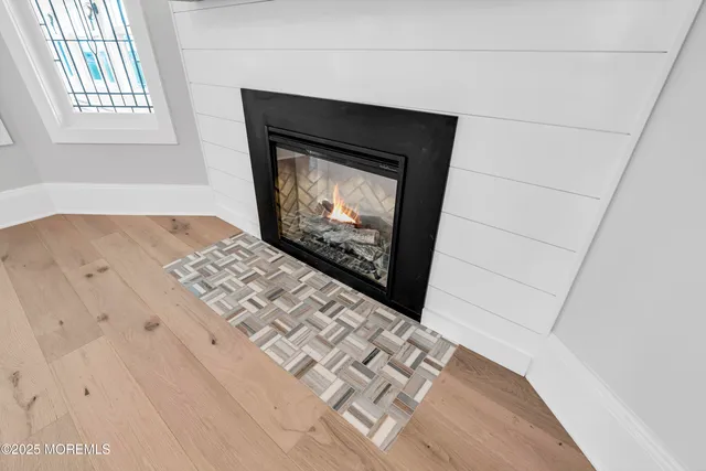 a view of a hallway with wooden floor and a bathroom