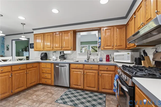 a kitchen with stainless steel appliances granite countertop sink stove and refrigerator