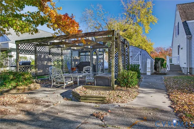 a view of a white house with a small yard and large tree