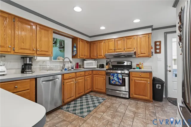 a kitchen with stainless steel appliances granite countertop a stove a sink dishwasher and a refrigerator