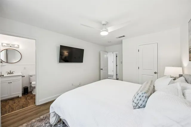 a spacious bedroom with a bed and a flat screen tv