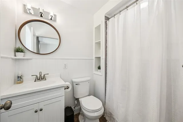 a bathroom with a sink a toilet and a mirror