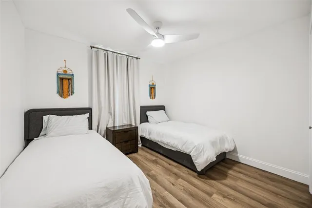 a bedroom with two beds and a night stand