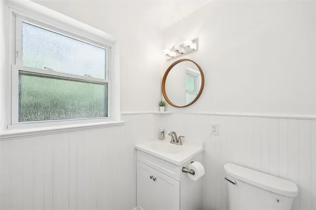 a bathroom with a sink mirror and toilet