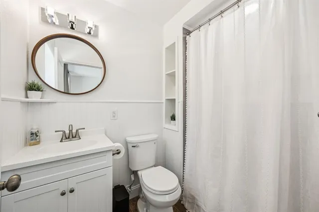 a bathroom with a sink a toilet and a mirror