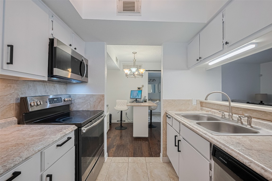 1505 Ward Road, Unit 118 Baytown, TX 77520 - Photo 14 of 35 a kitchen with granite countertop a sink dishwasher stove and oven with wooden floor