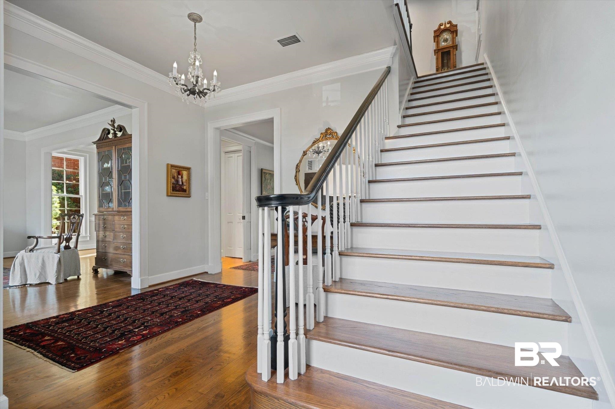 3615 Stein Street Mobile, AL 36608 - Photo 4 of 44 Staircase featuring crown molding, wood finished floors, and a chandelier