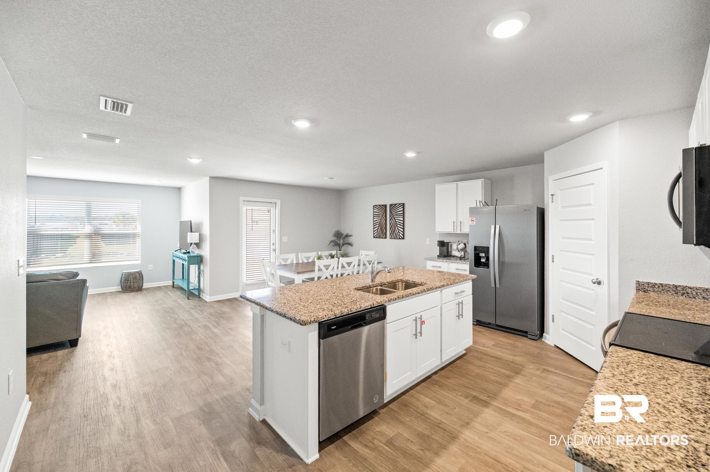 7425 Coppin Drive Foley, AL 36535 - Photo 8 of 41 Kitchen with sink, light wood-type flooring, white cabinetry, stainless steel appliances, and a kitchen island with sink