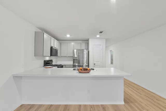 a kitchen with stainless steel appliances a sink stove and cabinets