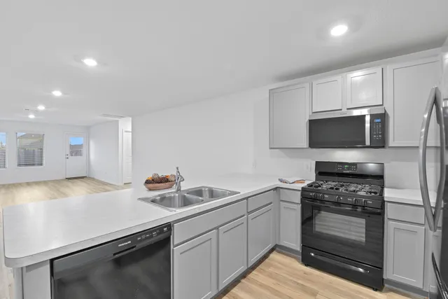 a kitchen with sink a microwave and cabinets