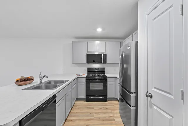a kitchen with stainless steel appliances granite countertop a refrigerator and a sink