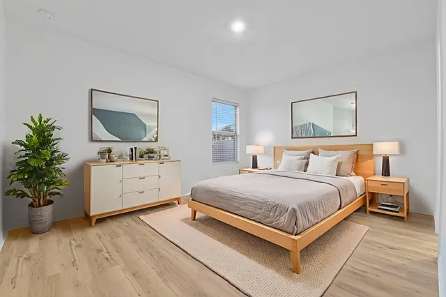 a bedroom with a large bed and a flat tv screen on dresser